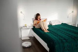 mujer sentada en cama de 2 plazas mientras lee