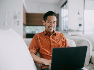 Hombre sonriente usando laptop