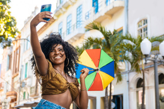 Mulher dança frevo enquanto faz uma selfie com um smartphone