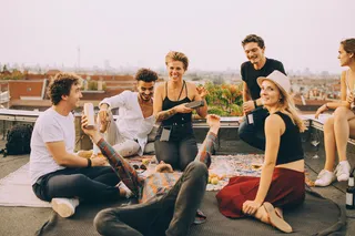 Grupo de amigos escuchando música a través de un parlante portátil
