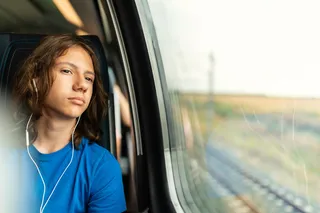 Joven viajando con sus auriculares in-ear con cable