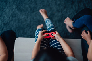 criança jogando em console portåtil