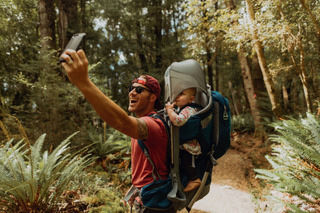 Un hombre se toma una selfie mientras recorre un frondoso bosque