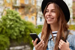 Mujer sonriente sostiene celular