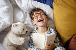 Menino lendo um livro.