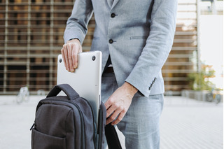Hombre guardando laptop en su mochila