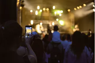 Mujer con celular en un concierto