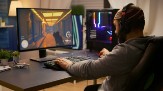 Homem jogando em PC Gamer com gabinete com luzes RGB.