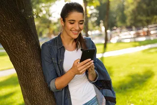 Mujer sonriendo mira su celular