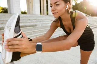 Mulher se alongando com smartwatch