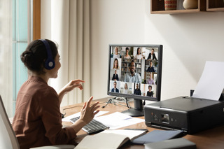 Uma mulher conecta sua webcam para uma reunião de trabalho