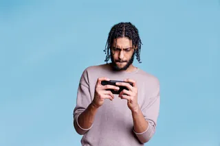 Homem jogando em console portátil