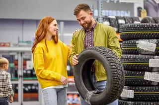 Casal escolhendo pneus de carro
