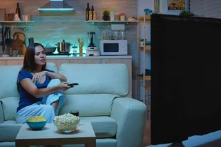 Mulher assistindo TV no sofá