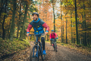 Casal pratica mountain bike em uma floresta