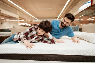 Padre e hijo probando colchón en tienda