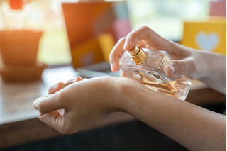 Aplicación de perfume en mano
