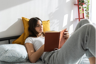 Mujer leyendo recostada en la cama