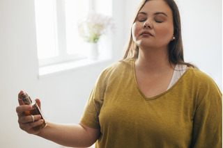 Mujer aplicando perfume