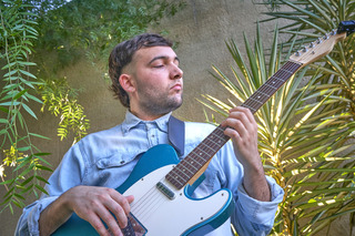 Homem tocando uma Fender Telecaster.