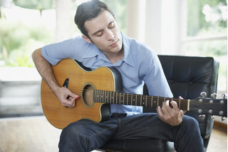 Homem tocando uma guitarra acústica