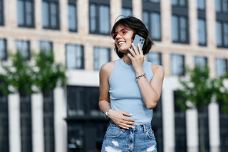 Mulher fala ao smartphone enquanto está ao ar livre