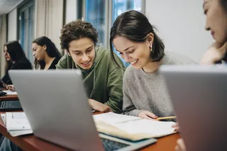 Jóvenes estudiantes junto a un computador