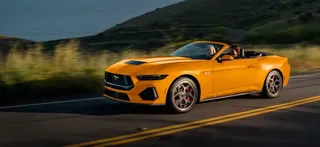 Ford Mustang GT 2026 amarillo circulando por carretera costera