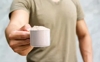 Homem segurando scoop de proteina