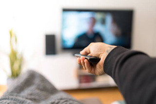 Homem assistindo TV em seu sofá