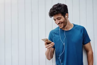 Un hombre joven escucha música con su celular Motorola