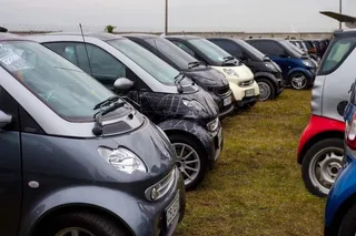Autos Smart compactos estacionados alineados en el exterior.