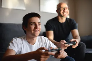 Um homem e um garoto jogam video game