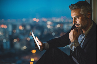 hombre de negocios mirando la tableta digital por la noche