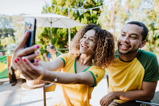 Um casal tira uma selfie enquanto torce pela verde-amarela
