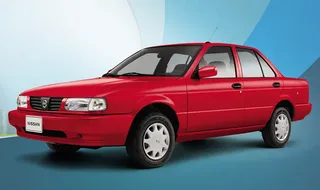 Automóvil sedán rojo estacionado sobre fondo claro.