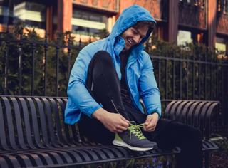 Hombre con chaqueta deportiva atando sus tenis
