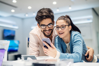 Una pareja escogiendo un celular en una tienda de electrónica