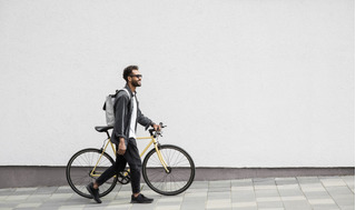 Homem caminha ao lado da sua bicicleta aro 29