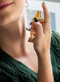 Mulher borrifando perfume no pescoço