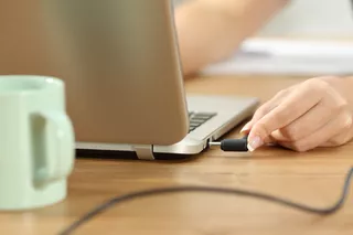 Una persona conecta su notebook para ser cargada tras extensas horas de uso