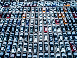 Vista aérea de filas ordenadas de automóviles estacionados.