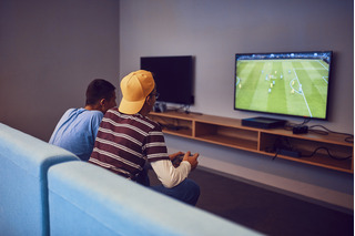 Pessoas jogando futebol em videogame