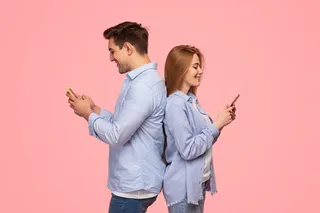 Pareja de espaldas usan smartphones de diferentes marcas