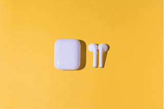 Auriculares inalámbricos blancos de moda sobre fondo amarillo