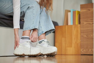 Mujer poniéndose Zapatillas Altas