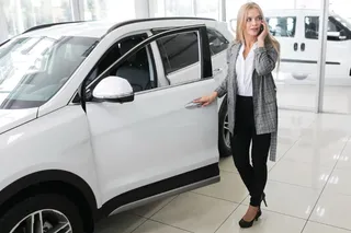 Mujer abriendo un SUV Mazda CX 30 blanco en concesionario