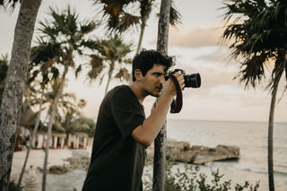 Un joven toma una foto con su cámara fotográfica en una playa de Tulum.