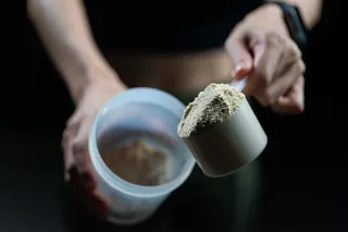 mulher con scoop de proteina en po
