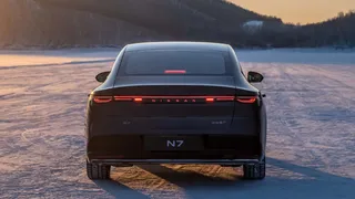 A traseira exibe uma barra luminosa robusta e o logotipo da Nissan.